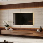 A luxurious Budget-friendly TV wall idea featuring vertical wood slats, a marble-textured accent panel, and warm LED backlighting. A floating wooden console sits below a wall-mounted TV in a modern living room setting.