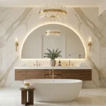 Luxury master bathroom with gold marble statement wall, floating walnut vanity, backlit arched mirror, and freestanding tub.
